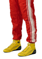 Yellow high-top racing-style shoes worn with red racing trousers